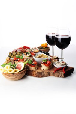 İtalyan antipasti şarap aperatifler küme. Peynir çeşitli, Akdeniz zeytin, turşu, Prosciutto di Parma, domates, enginar ve masada bardaklarda şarap