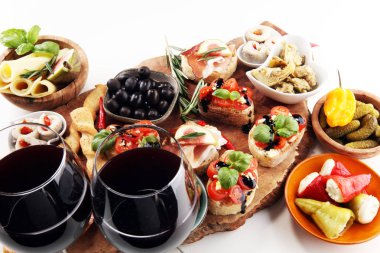 İtalyan antipasti şarap aperatifler küme. Peynir çeşitli, Akdeniz zeytin, turşu, Prosciutto di Parma, domates, enginar ve masada bardaklarda şarap
