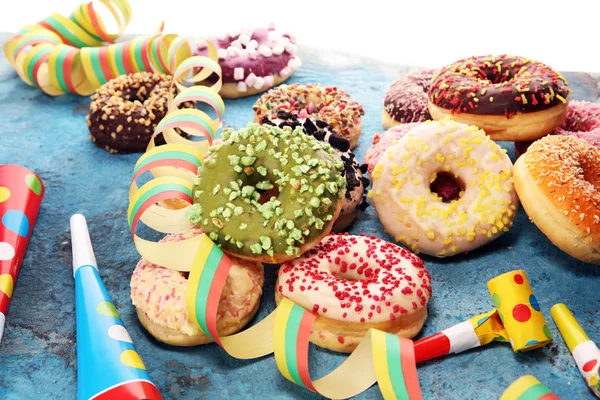 Çikolatalı buzlu, pembe sırlı ve bonibon donuts ile çeşitli çörekler. Karnaval kavramı.