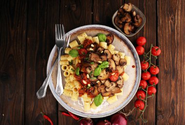 Mantar ile domates sosu penne makarna Rigatoni, maydanoz ve fesleğen ile süslenmiş domates