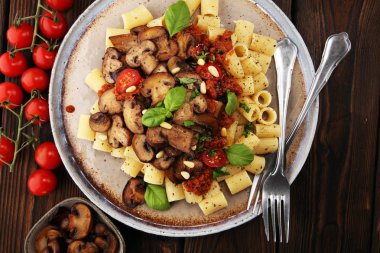 Mantar ile domates sosu penne makarna Rigatoni, maydanoz ve fesleğen ile süslenmiş domates