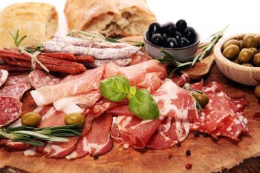 Jambon, pastırma, salam ve sosis ahşap arka plan üzerinde mermer kesme tahtası. Et tabağı meze ve zeytin