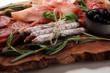 Jambon, pastırma, salam ve sosis ahşap arka plan üzerinde mermer kesme tahtası. Et tabağı meze ve zeytin