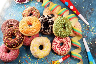 Çikolatalı buzlu, pembe sırlı ve bonibon donuts ile çeşitli çörekler. Karnaval kavramı.