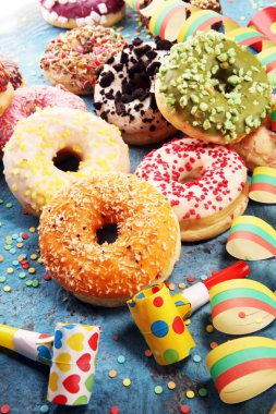 Çikolatalı buzlu, pembe sırlı ve bonibon donuts ile çeşitli çörekler. Karnaval kavramı.