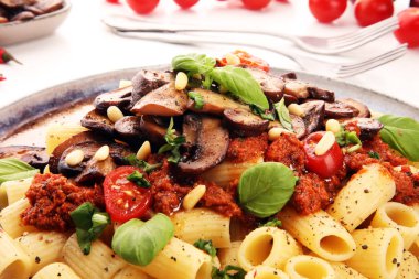 Mantar ile domates sosu penne makarna Rigatoni, maydanoz ve fesleğen ile süslenmiş domates