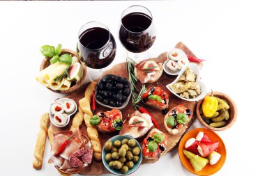 İtalyan antipasti şarap aperatifler küme. Peynir çeşitli, Akdeniz zeytin, turşu, Prosciutto di Parma, domates, enginar ve masada bardaklarda şarap