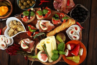 İtalyan antipasti şarap aperatifler küme. Peynir çeşitli, Akdeniz zeytin, turşu, Prosciutto di Parma, domates, enginar masada
