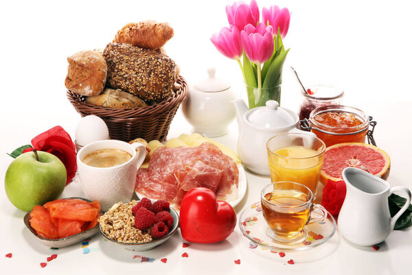 завтрак на столе с булочками, круассанами, стримерами, кофе и соком на карнавале
