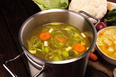 Et suyu ile havuç, soğan bir tencerede - renkli taze açık bahar çorbası çeşitli taze sebze. Kırsal mutfak sahne vejetaryen bouillon