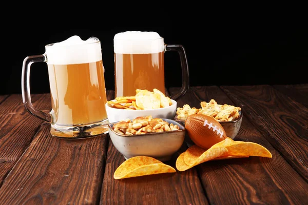 Chips, salty snacks, football and Beer on a table. Great for Bowl Game projects.