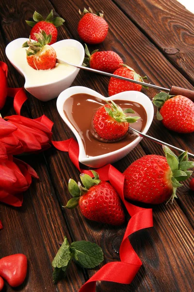 Valentine Chocolate fondue melted with fresh strawberries and dark and white chocolate. Tublips and red sugar hearts