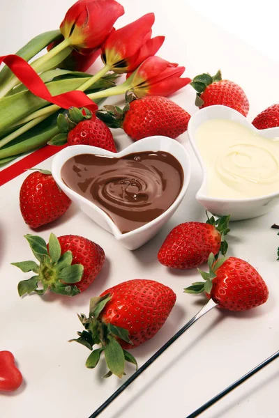 Valentine Chocolate fondue melted with fresh strawberries and dark and white chocolate. Tublips and red sugar hearts