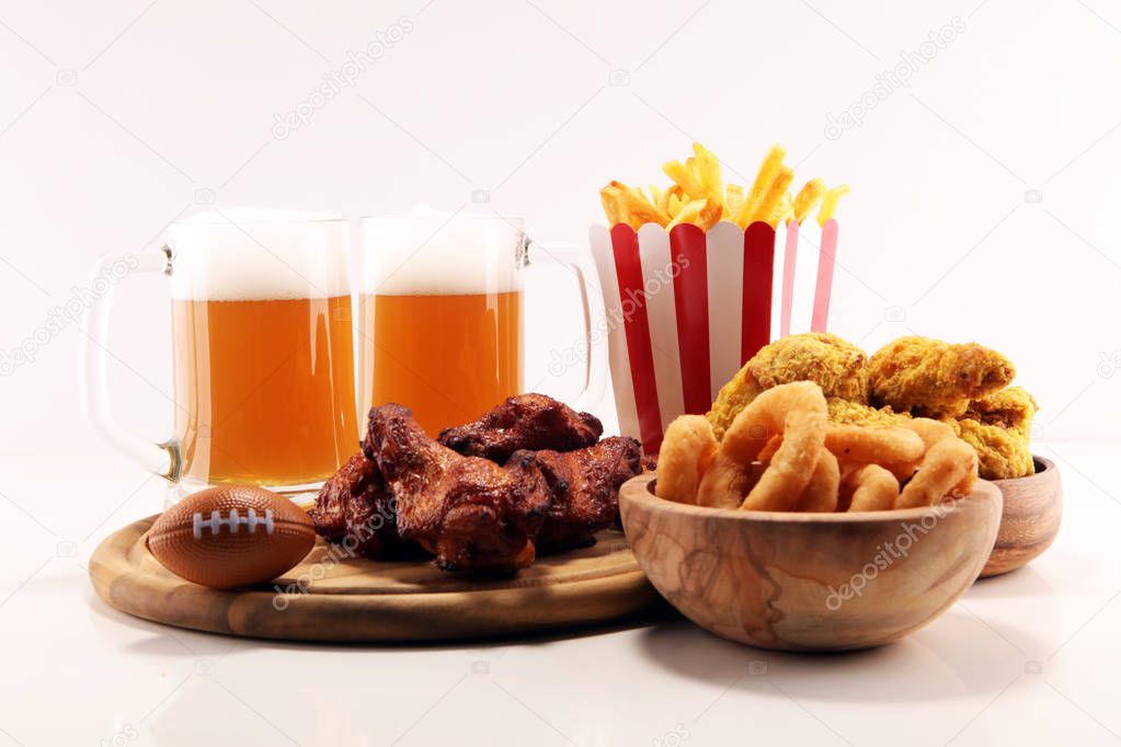 chicken wings, fries, beer and onion rings for football on a table. Great for Bowl football Game