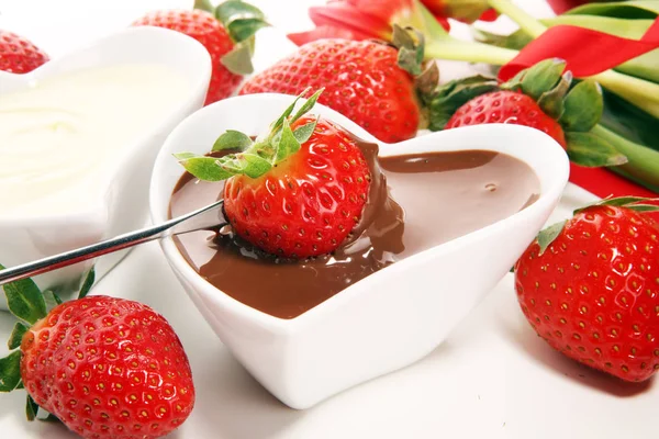 Valentine Chocolate fondue melted with fresh strawberries and dark and white chocolate. Tublips and red sugar hearts