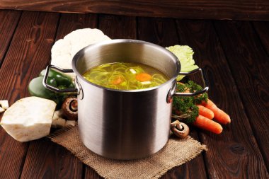 Et suyu ile havuç, soğan bir tencerede - renkli taze açık bahar çorbası çeşitli taze sebze. Kırsal mutfak sahne vejetaryen bouillon