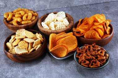 Tuzlu atıştırmalıklar. Simitler, cipsler, tahta kaselerde krakerler. Sağlıksız ürünler. Yemek vücut, deri, kalp ve dişler için kötüdür. Fast karbonhidrat besin çeşitleri. 