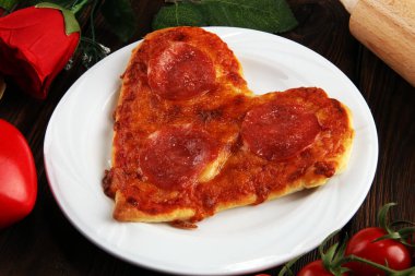 Sevgililer günü pizza karanlık rustik ahşap arka plan üzerinde kalp şeklinde. Sevgililer kalp pizza yemek