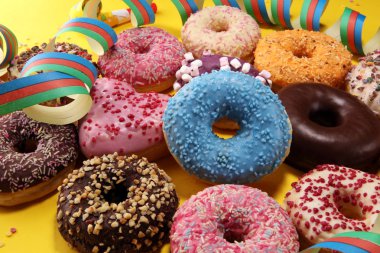 Çikolatalı buzlu, pembe sırlı ve bonibon donuts ile çeşitli çörekler. Karnaval kavramı.