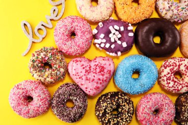 Çikolatalı buzlu, pembe sırlı ve bonibon donuts ile çeşitli çörekler. Karnaval kavramı.