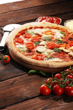 Pizza domates, mozzarella peyniri, Siyah Zeytin ve fesleğen. Lezzetli İtalyan pizza ahşap pizza yönetim kurulu üzerinde. İtalyan pizza