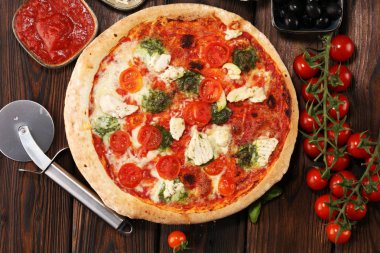 Pizza domates, mozzarella peyniri, Siyah Zeytin ve fesleğen. Lezzetli İtalyan pizza ahşap pizza yönetim kurulu üzerinde. İtalyan pizza