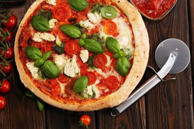 Pizza domates, mozzarella peyniri, Siyah Zeytin ve fesleğen. Lezzetli İtalyan pizza ahşap pizza yönetim kurulu üzerinde. İtalyan pizza