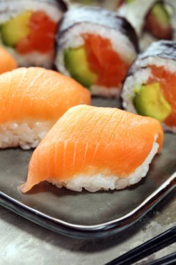 sashimi suşi kümesi çubuklarla kadar yakın ve soya - suşi rulo ile somon ve suşi rulo füme yılan balığı ile seçici odak.