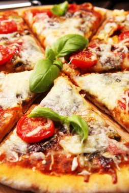 Eritilmiş peynir, kırmızı domates ve peynir, domates ve kırmızı kiraz domates tarafından dekore edilmiş bir tabloda yeşil fesleğen vejetaryen İtalyan pizza