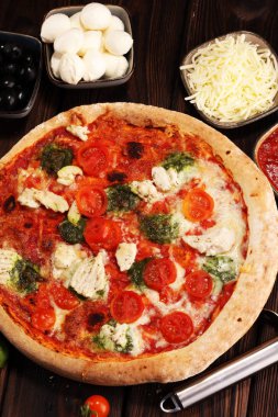 Pizza domates, mozzarella peyniri, Siyah Zeytin ve fesleğen. Lezzetli İtalyan pizza ahşap pizza yönetim kurulu üzerinde. İtalyan pizza