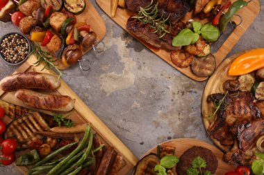 Çeşit çeşit lezzetli ızgara et, sebze ve kırsal masada otlar.