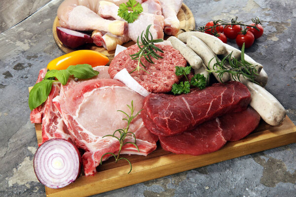 raw meat. Different types of raw pork meat, chicken and beef with spices and herbs and sausages