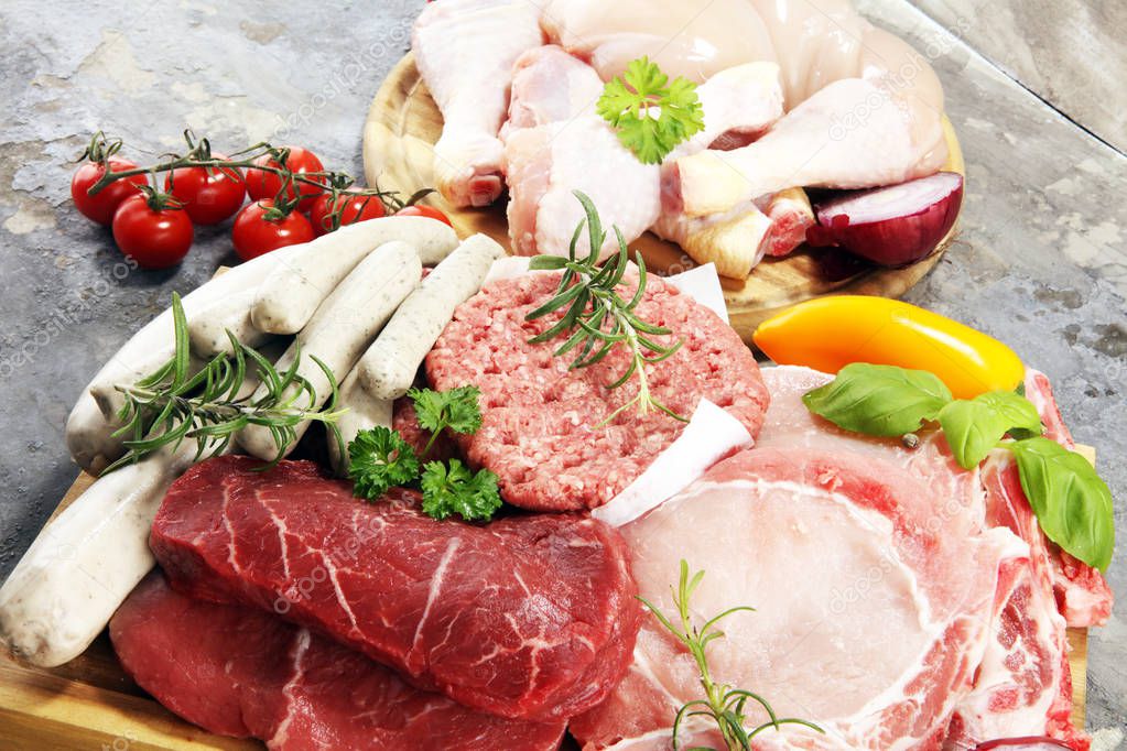 raw meat. Different types of raw pork meat, chicken and beef with spices and herbs and sausages