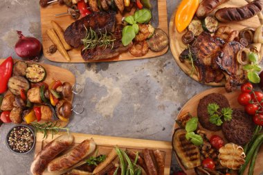 Çeşit çeşit lezzetli ızgara et, sebze ve kırsal masada otlar.