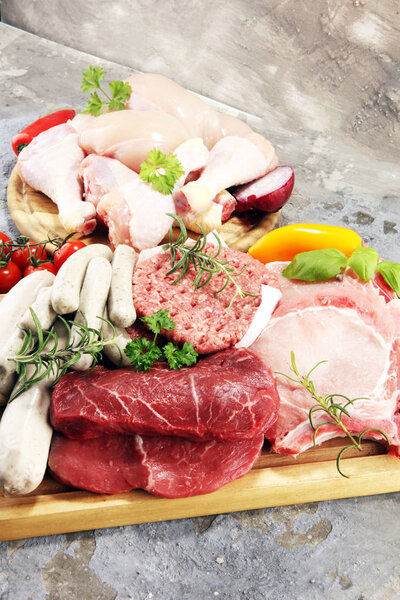 raw meat. Different types of raw pork meat, chicken and beef with spices and herbs and sausages