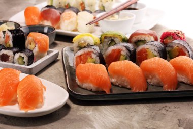 sashimi suşi kümesi çubuklarla kadar yakın ve soya - suşi rulo ile somon ve suşi rulo füme yılan balığı ile seçici odak.