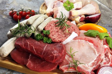 raw meat. Different types of raw pork meat, chicken and beef with spices and herbs and sausages clipart