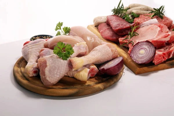 raw meat. Different types of raw pork meat, chicken and beef with spices and herbs and sausages