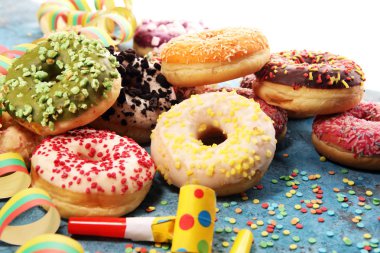 Çikolatalı buzlu, pembe sırlı ve bonibon donuts ile çeşitli çörekler. Karnaval kavramı.