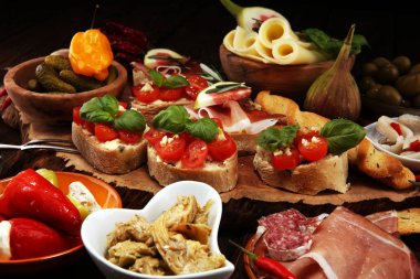 İtalyan antipasti şarap aperatifler küme. Peynir çeşitli, Akdeniz zeytin, turşu, Prosciutto di Parma, domates, enginar masada