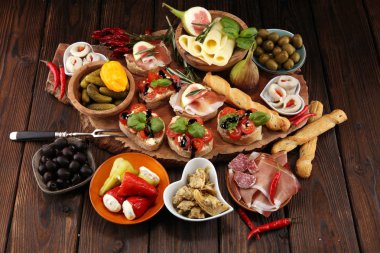 İtalyan antipasti şarap aperatifler küme. Peynir çeşitli, Akdeniz zeytin, turşu, Prosciutto di Parma, domates, enginar masada