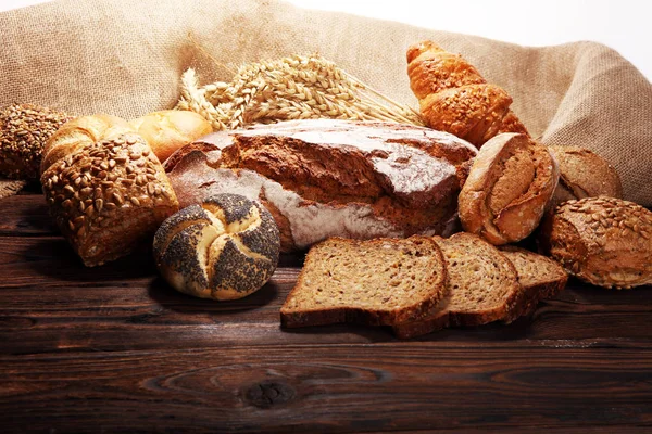 Different kinds of bread and bread rolls on board from above. Kitchen or bakery poster design.