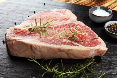 Taş kesme tahtası üzerinde ham T-bone biftek.