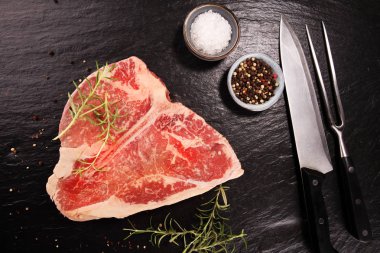 Taş kesme tahtası üzerinde ham T-bone biftek.