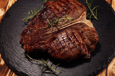 Taş kesme tahtası üzerinde ızgara T-bone biftek.