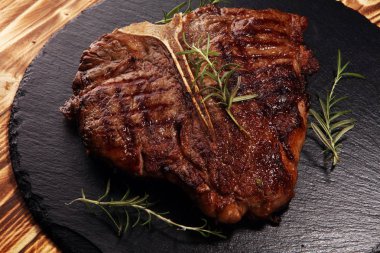 Taş kesme tahtası üzerinde ızgara T-bone biftek.