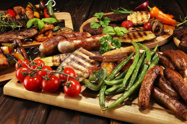 Assorted delicious grilled meat with vegetable on rustic table — Stock Photo, Image