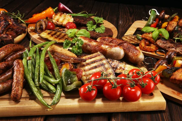 Surtido de deliciosa carne a la parrilla con verduras en mesa rústica — Foto de Stock