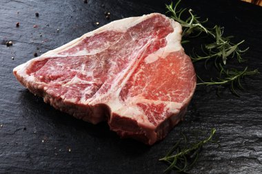 Taş kesme tahtası üzerinde ham T-bone biftek.