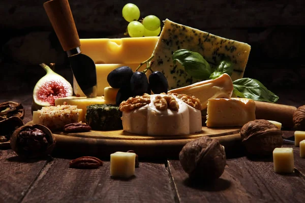 Cheese plate served with figs, various cheese on a platter on wo — Stock Photo, Image